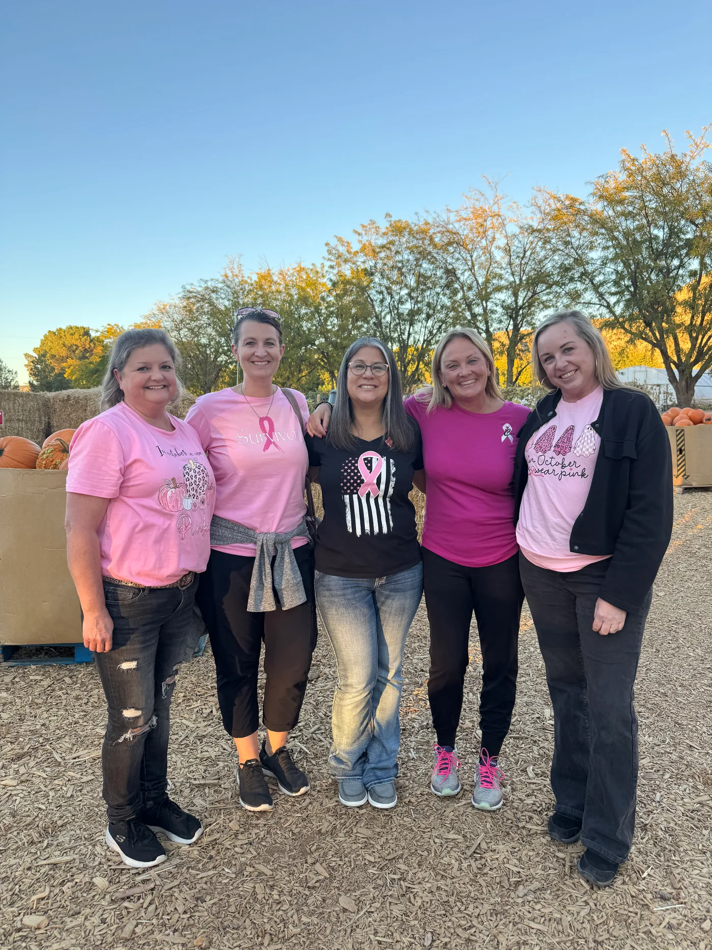 Jen with a group of breast cancer survivors at an October pumpkin patch, all wearing pink
